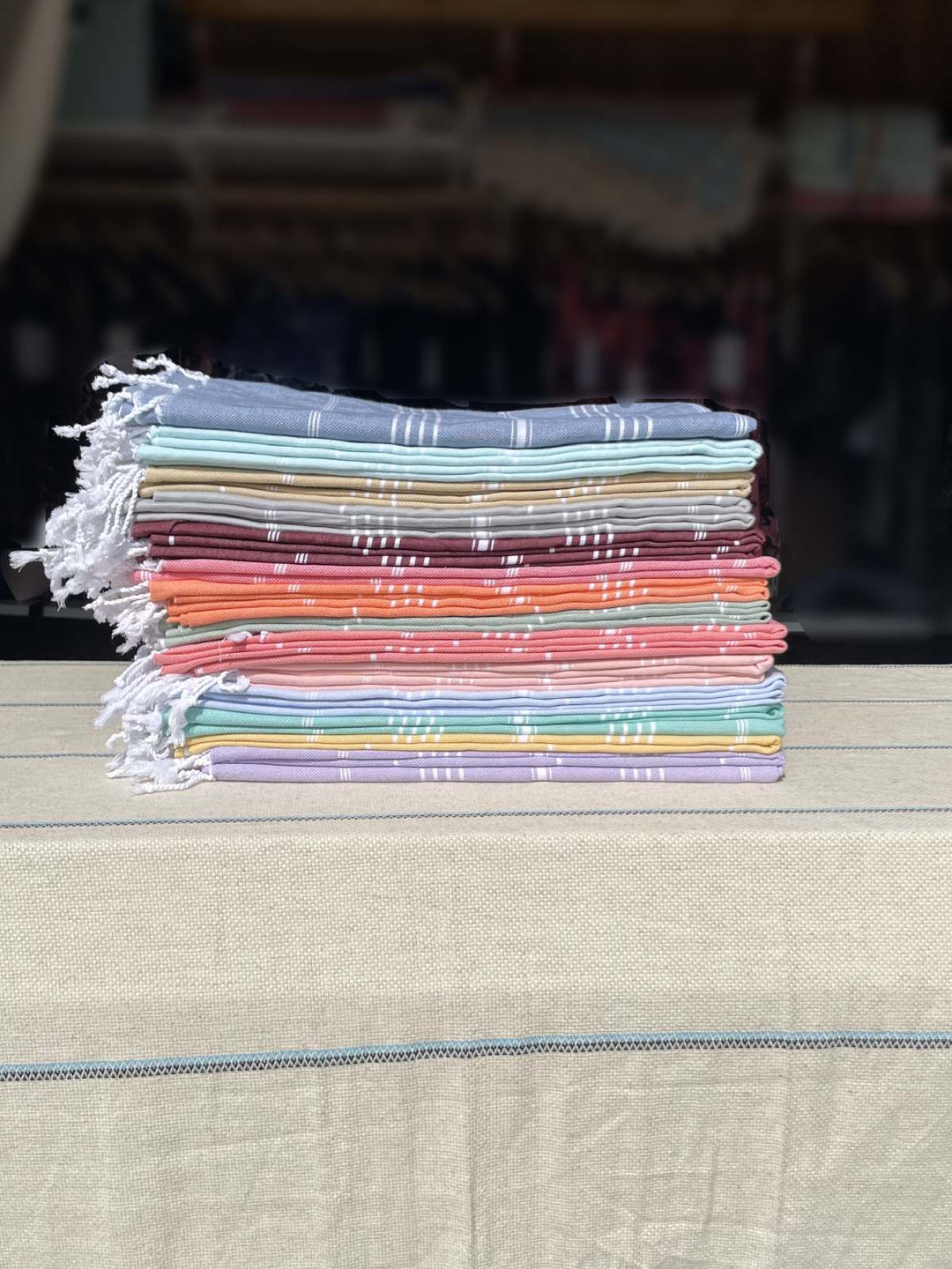 Stack of colorful fabric towels on a wooden surface with a blurred background