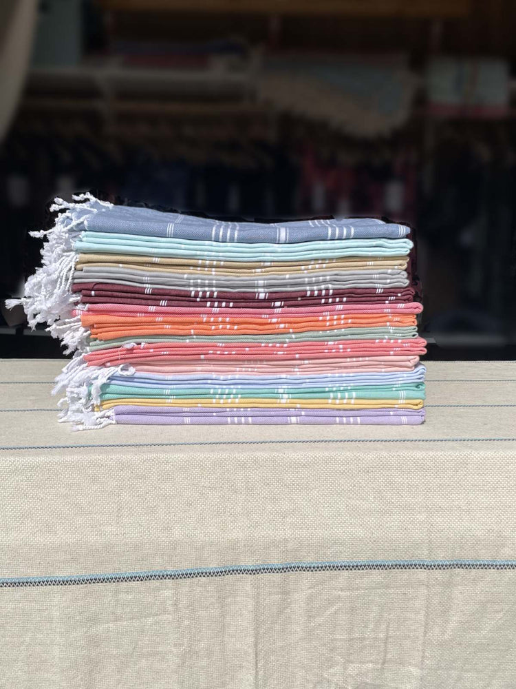Stack of colorful fabric towels on a wooden surface with a blurred background